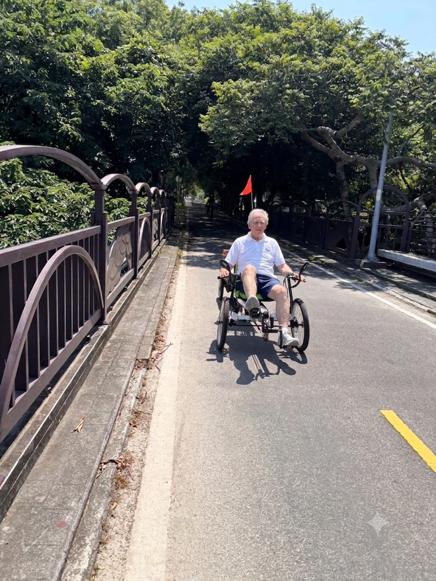 Smiling senior man riding a recumbent electric trike across a scenic park bridge on a sunny day